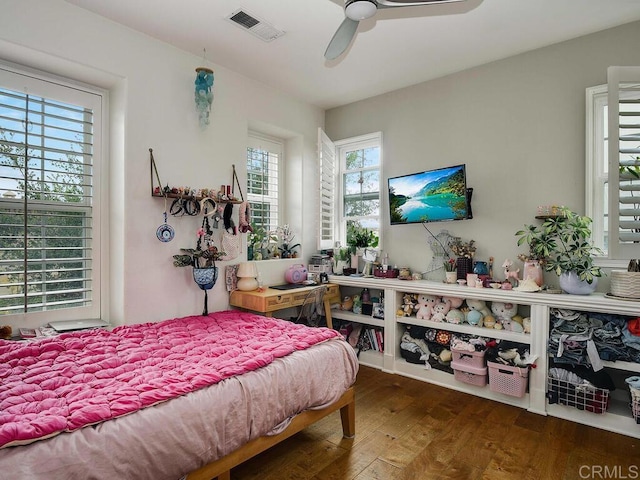 bedroom featuring wood-type flooring, a ceiling fan, and visible vents