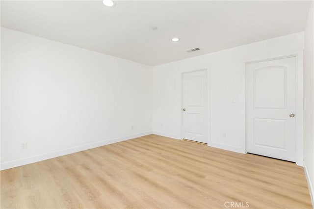 spare room featuring recessed lighting, light wood-style floors, baseboards, and visible vents
