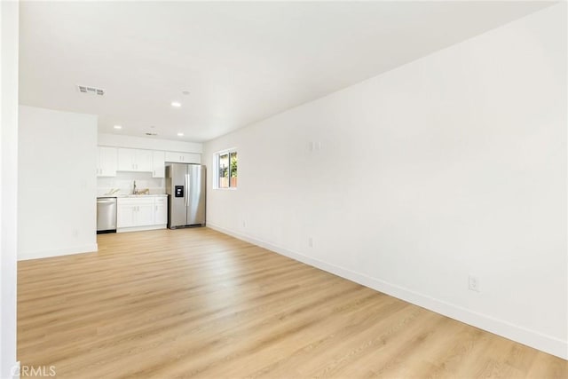 unfurnished living room with recessed lighting, baseboards, visible vents, and light wood-type flooring