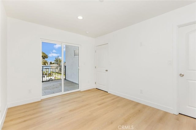 spare room featuring recessed lighting, baseboards, and light wood-type flooring