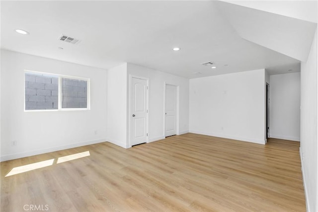 unfurnished room featuring recessed lighting, light wood-style flooring, baseboards, and visible vents