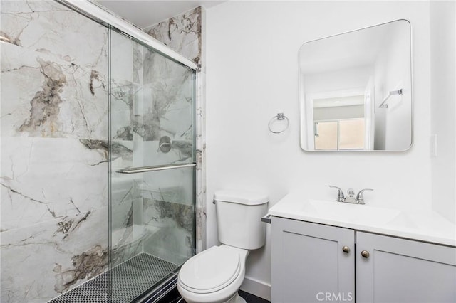 bathroom with vanity, a marble finish shower, and toilet