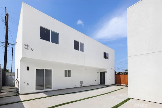 back of house featuring stucco siding, a patio area, and fence