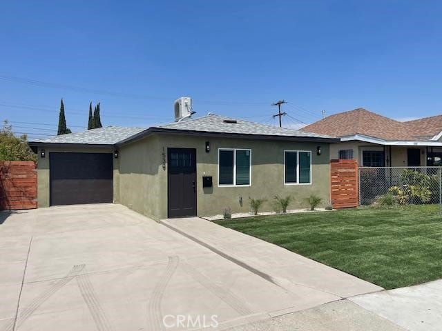 ranch-style home with a garage, fence, a front yard, stucco siding, and driveway