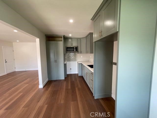 1539 E 87th St, Los Angeles, CA 90002 - kitchen with stainless steel microwave, gray cabinetry, decorative backsplash, dark wood-style flooring, and recessed lighting