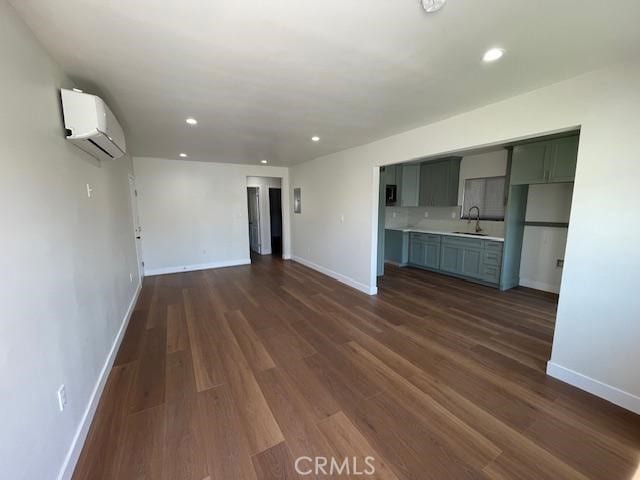 1539 E 87th St, Los Angeles, CA 90002 - unfurnished living room featuring a wall unit AC, dark wood-style floors, baseboards, and recessed lighting