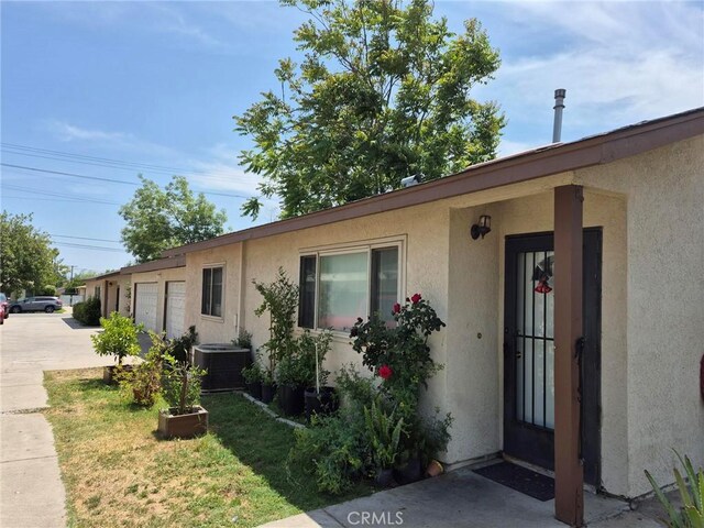 409 E Belmont St, Ontario, CA 91761 - view of front of property featuring stucco siding, driveway, and a garage