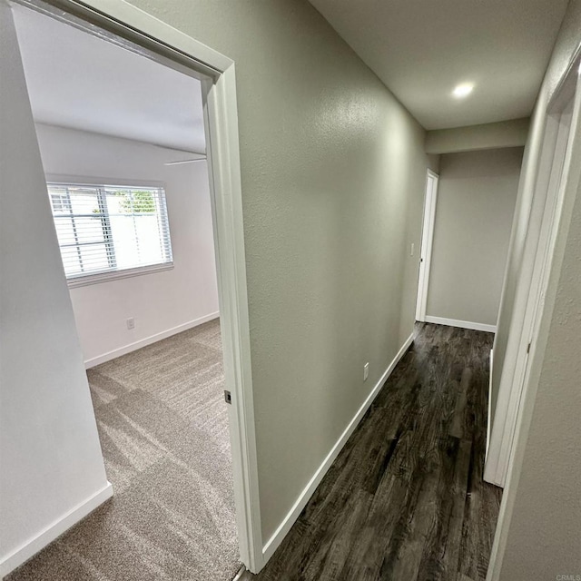 hallway featuring baseboards and wood finished floors