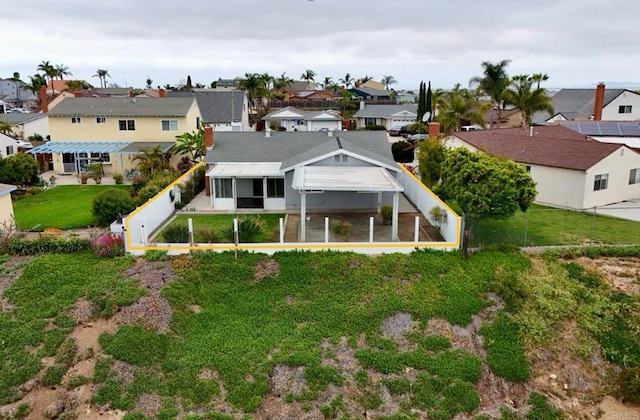 rear view of property with a sunroom, a fenced backyard, a yard, and a residential view