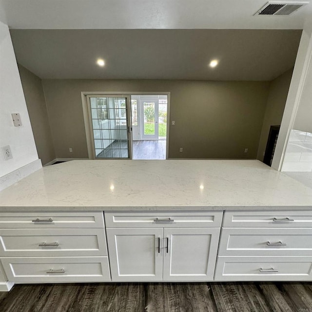 kitchen with white cabinetry, light stone countertops, visible vents, and recessed lighting