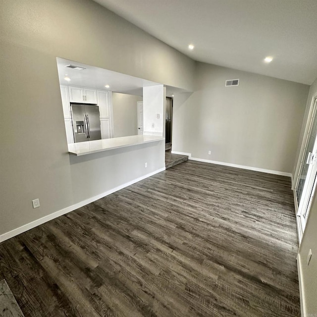 unfurnished living room with visible vents, recessed lighting, dark wood-type flooring, and vaulted ceiling