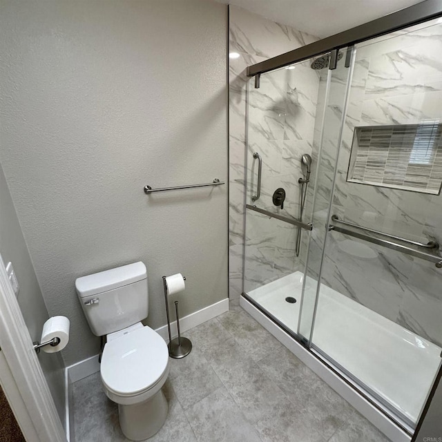 full bathroom featuring toilet, baseboards, and a marble finish shower