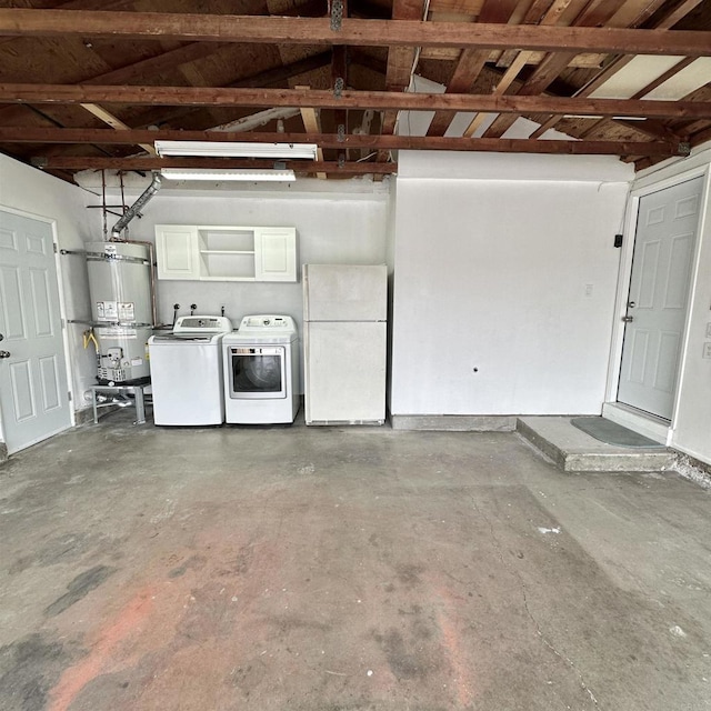 garage with freestanding refrigerator, water heater, and independent washer and dryer