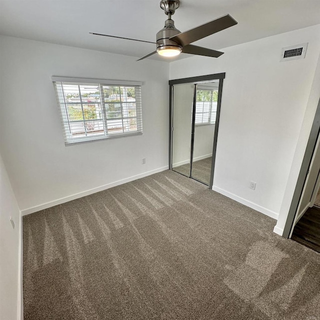 unfurnished bedroom featuring carpet floors, baseboards, visible vents, and a closet