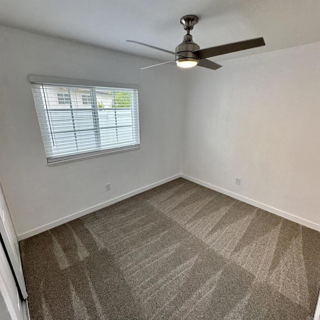 carpeted empty room with baseboards and a ceiling fan