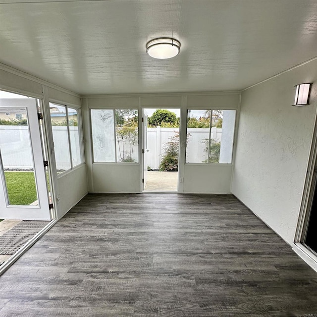 unfurnished sunroom featuring a textured wall and wood finished floors