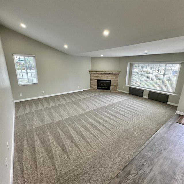 unfurnished living room featuring recessed lighting, baseboards, a wealth of natural light, and wood finished floors