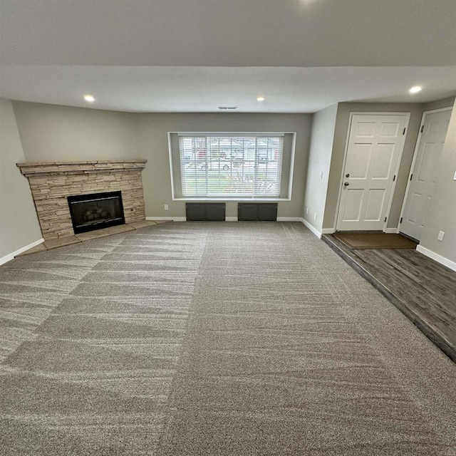 unfurnished living room with baseboards, a fireplace, and recessed lighting
