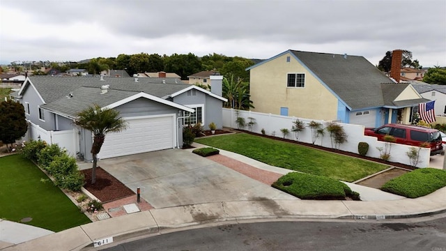 view of front facade with an attached garage, fence, driveway, and a front yard