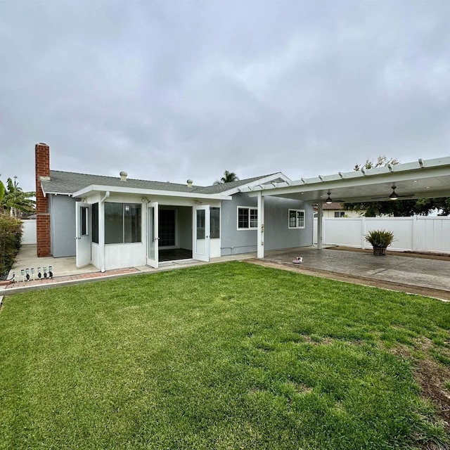 back of house with fence, a patio, roof with shingles, stucco siding, and a yard