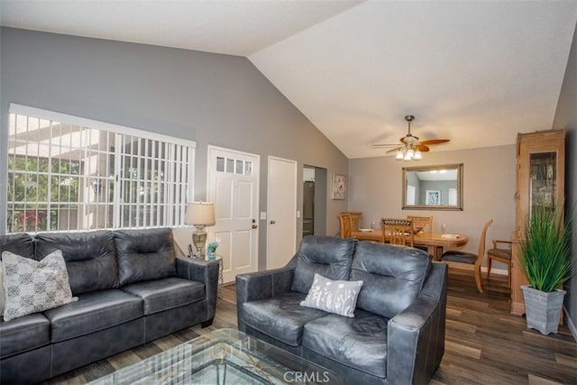 living area with baseboards, a ceiling fan, dark wood-style flooring, and high vaulted ceiling