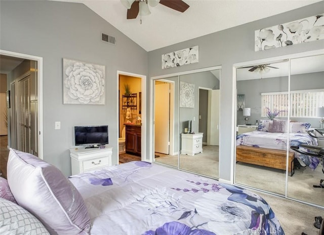 bedroom featuring visible vents, a ceiling fan, two closets, high vaulted ceiling, and carpet flooring