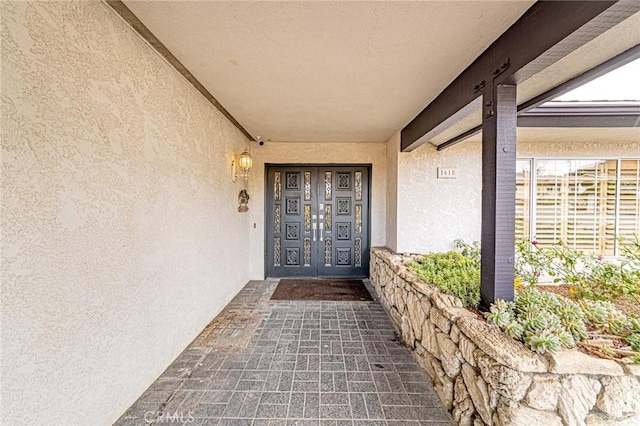 view of exterior entry featuring stucco siding