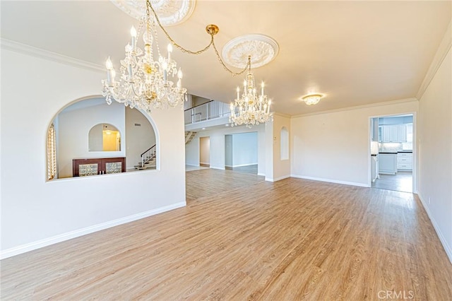 unfurnished dining area with crown molding, stairs, wood finished floors, baseboards, and a chandelier
