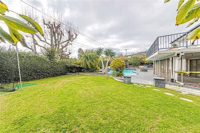 view of yard with a balcony and an outdoor pool