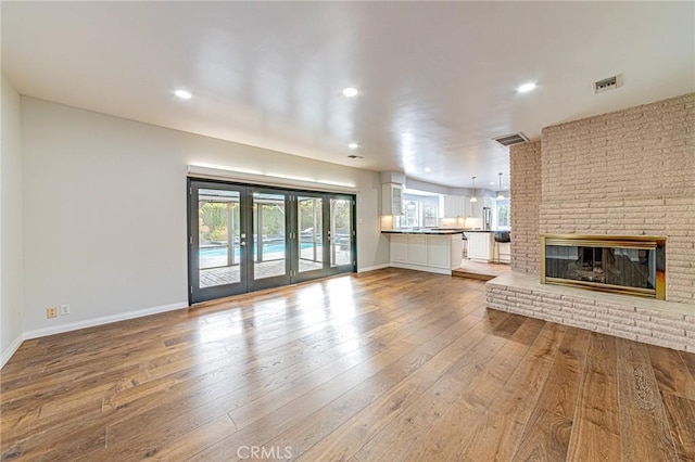 unfurnished living room featuring visible vents, recessed lighting, baseboards, and hardwood / wood-style flooring