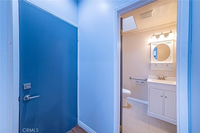 bathroom featuring tile patterned flooring, vanity, toilet, baseboards, and visible vents