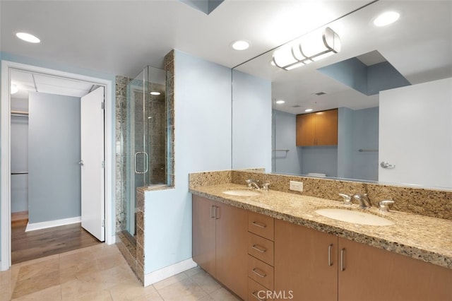 full bathroom with a sink, baseboards, and a stall shower