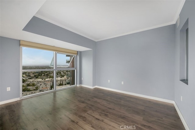 unfurnished room with crown molding, baseboards, and wood finished floors
