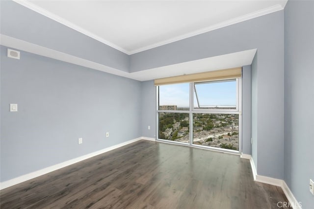 spare room with baseboards, ornamental molding, dark wood-style floors, and visible vents
