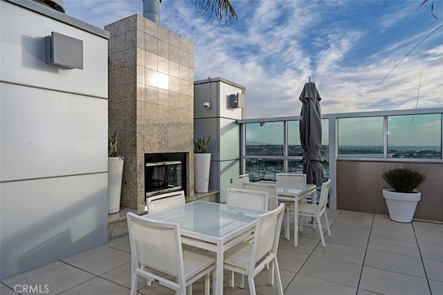 view of patio / terrace with a glass covered fireplace and outdoor dining area