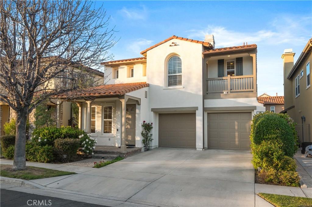 mediterranean / spanish house featuring driveway, a tile roof, a balcony, an attached garage, and stucco siding