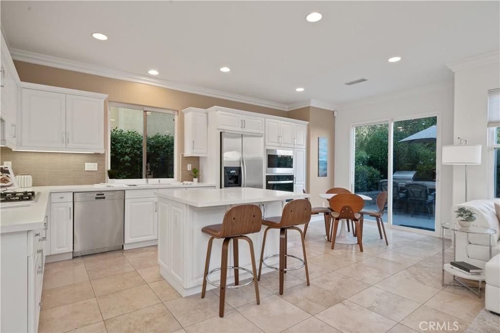 kitchen with white cabinets, appliances with stainless steel finishes, light countertops, recessed lighting, and decorative backsplash