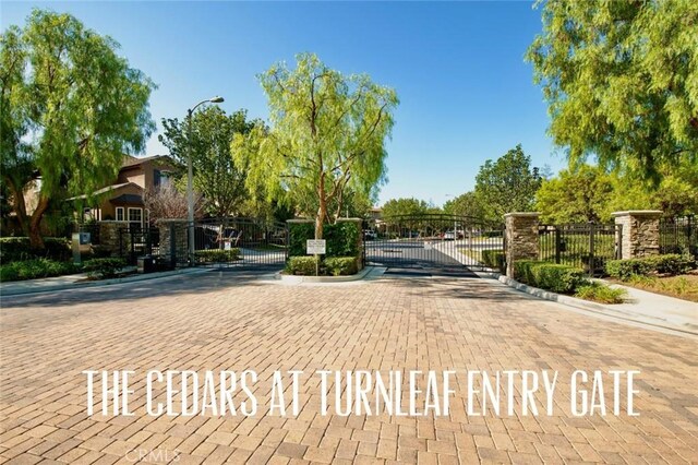 473 Periwinkle St, Fullerton, CA 92835 - view of street featuring a gate, curbs, a gated entry, and street lighting