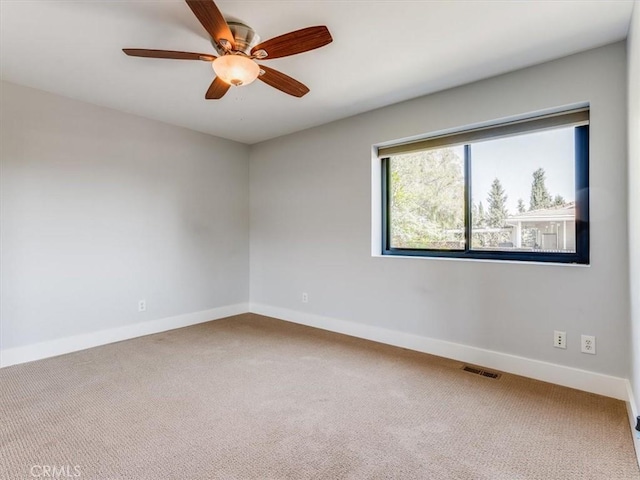 carpeted spare room featuring a ceiling fan, baseboards, and visible vents