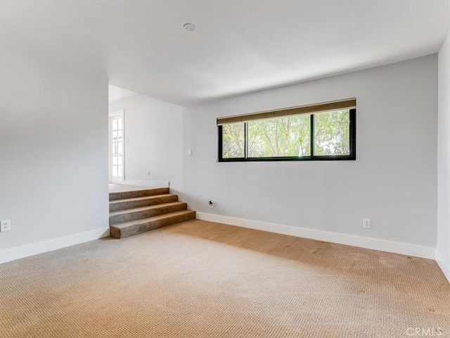 unfurnished room featuring carpet floors, baseboards, and a healthy amount of sunlight