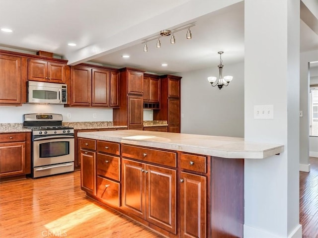 kitchen with appliances with stainless steel finishes, light countertops, a chandelier, recessed lighting, and light wood-style flooring
