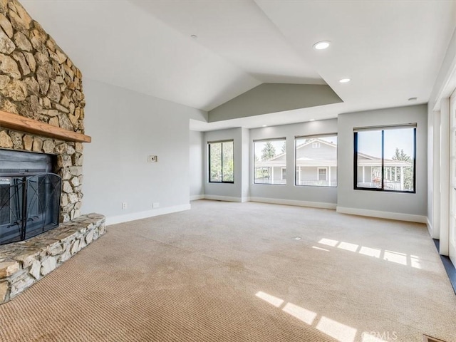 unfurnished living room with light colored carpet, baseboards, vaulted ceiling, and a fireplace