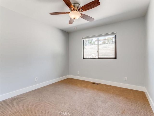 empty room featuring visible vents, a ceiling fan, carpet, and baseboards