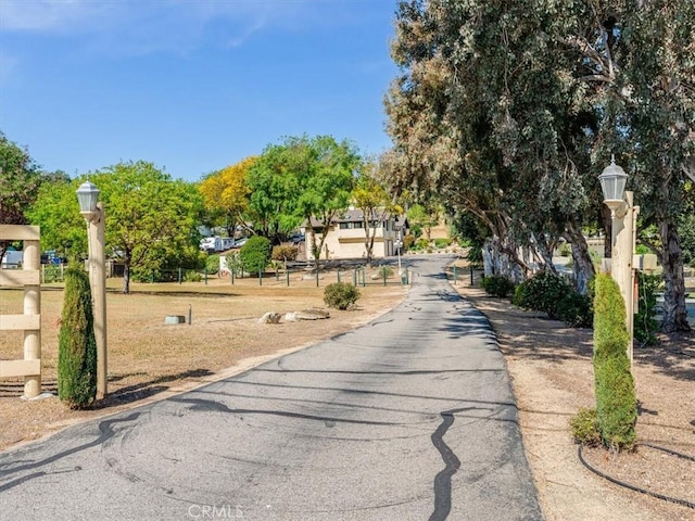 view of road with street lighting, a gated entry, and driveway