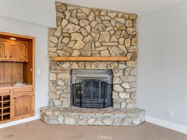 interior details with carpet floors, a sink, wet bar, and baseboards