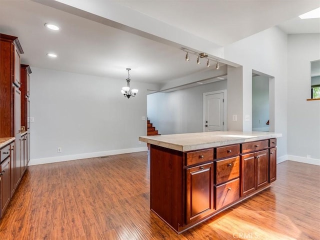 kitchen featuring light countertops, a chandelier, light wood-style flooring, recessed lighting, and baseboards