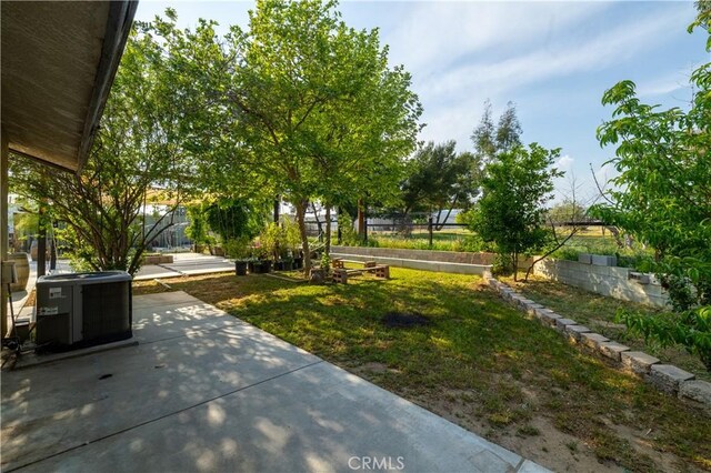 view of yard with a patio area, central air condition unit, and fence