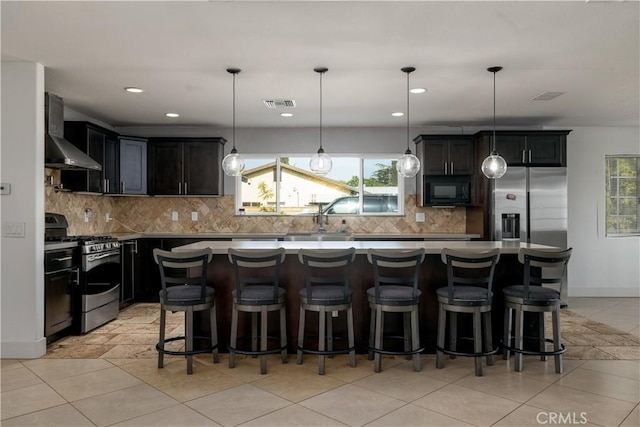 kitchen featuring plenty of natural light, wall chimney exhaust hood, stainless steel appliances, and visible vents