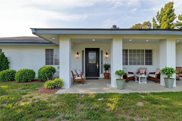 2485 W Westward Ave, Banning, CA 92220 - view of exterior entry featuring stucco siding, an outdoor living space, a yard, and a patio