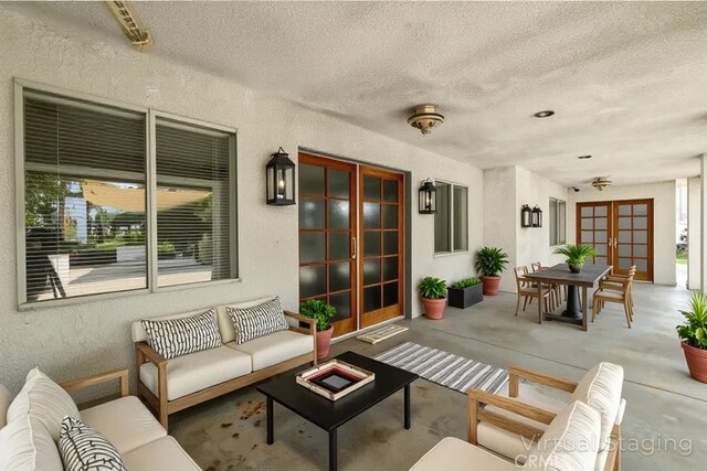 2485 W Westward Ave, Banning, CA 92220 - living area featuring french doors, a textured wall, a textured ceiling, and concrete flooring